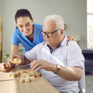 caregiver and elderly playing a puzzle